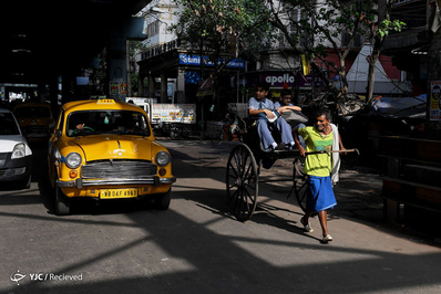 یک راننده ریکشای(گاری دستی) در کلکته مسافران خود را جابجا می کند. ریشکای یا همان گاری دستی یکی از اصلی ترین گزینه های حمل و نقل قرن نوزدهم، در هندوستان، امروزه تنها در کلکته استفاده می شود و در شهرهای دیگر هند ممنوع شده است.
